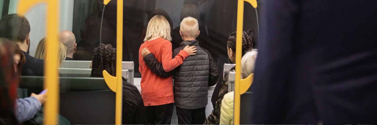 Två barn håller om varandra i ett metrotåg